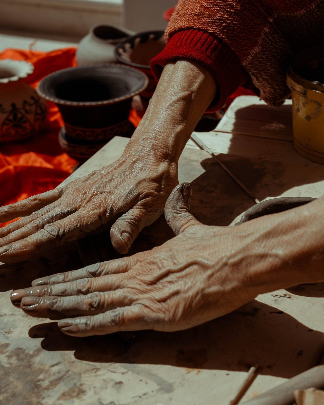 Le mani di un artigiano che lavorano l’argilla